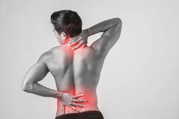 Illustrative photograph of a person indicating lower back discomfort